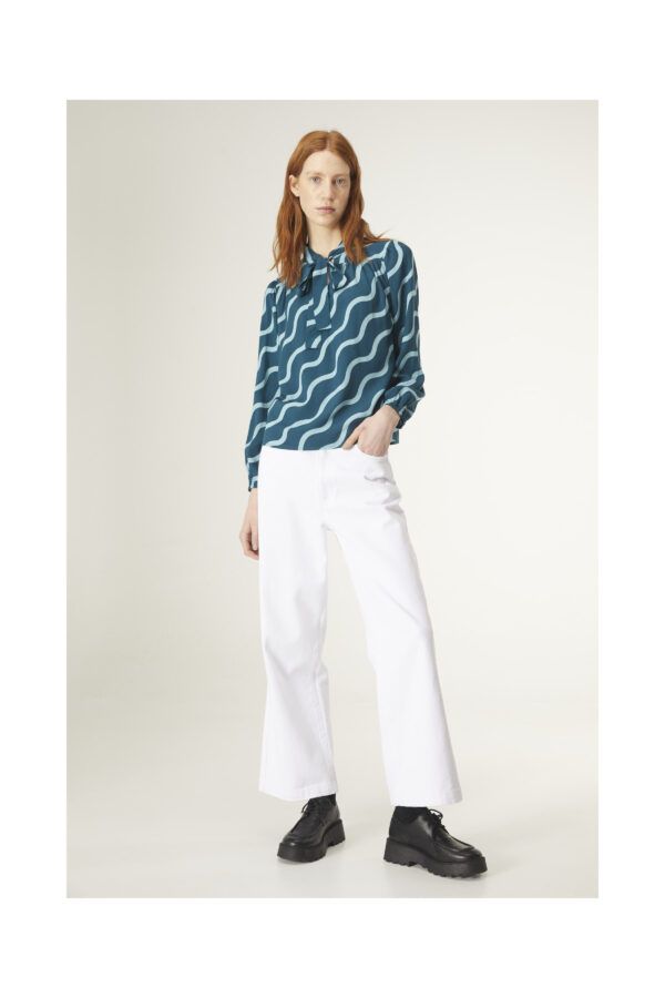Top con estampado geométrico de ondas. Con cuello lazada y manga larga. Canesú frontal y trasero con detalle de frunces. De Compañia Fantastica