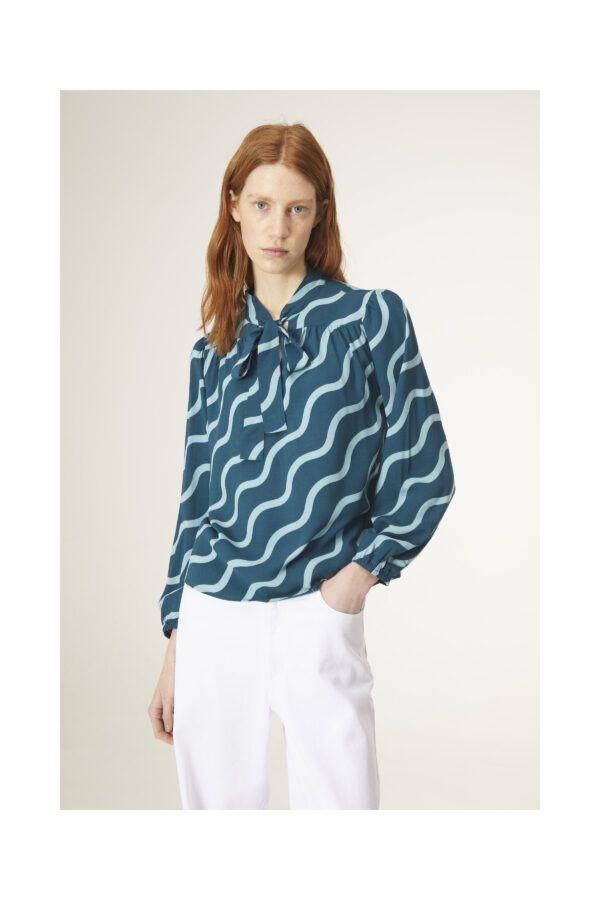 Top con estampado geométrico de ondas. Con cuello lazada y manga larga. Canesú frontal y trasero con detalle de frunces. De Compañia Fantastica