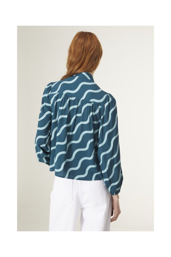 Top con estampado geométrico de ondas. Con cuello lazada y manga larga. Canesú frontal y trasero con detalle de frunces. De Compañia Fantastica