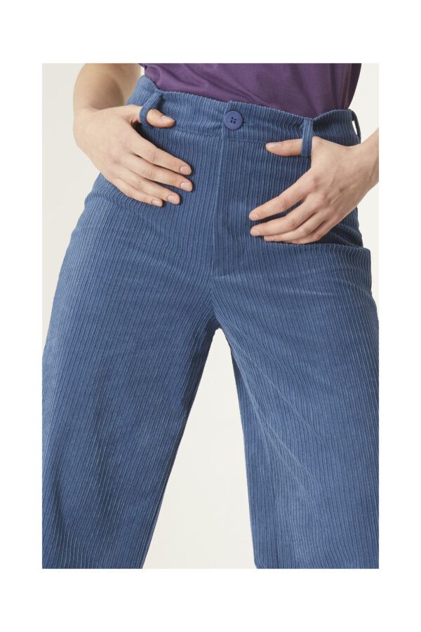 Pantalón de corte ancho en pana de color azul. Con cintura fija de tiro medio con cremallera y botón. Detalle de bolsillos parche traseros.Compañia Fantastica