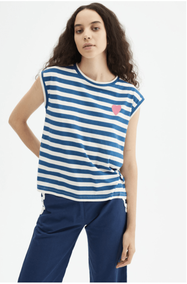 Camiseta básica blanca de algodón con estampado de rayas azules con detalle de corazón. Con cuello redondo y sin mangas. La modelo mide 179 cm y lleva la talla S.