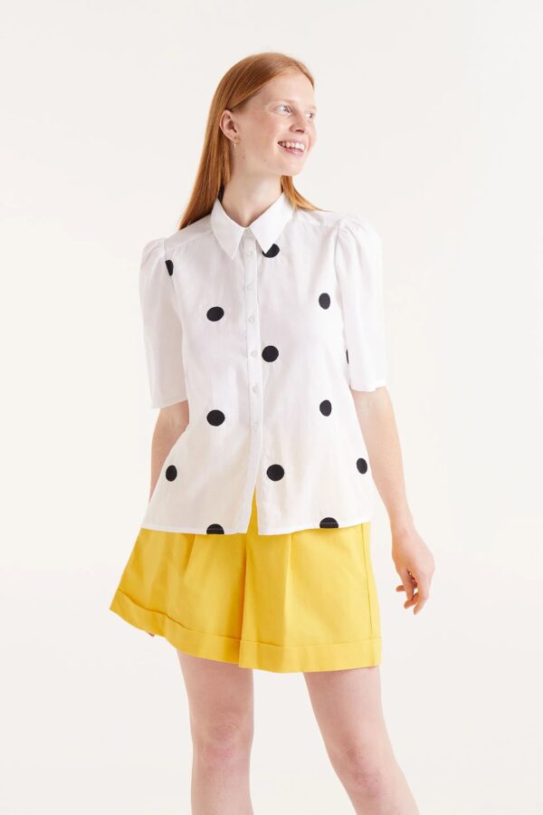 Camisa blanca de manga corta con lunares negros. Disponible en nuestra tienda multitareas en Badajoz, en el Casco Antiguo.