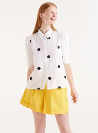 Camisa blanca de manga corta con lunares negros. Disponible en nuestra tienda multitareas en Badajoz, en el Casco Antiguo.