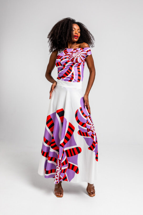 Top asimétrico Hola Caracola, estampado geométrico en lilas, rojos y blancos, con frunces y escote de un solo hombro. Disponible en Dulce Locura.