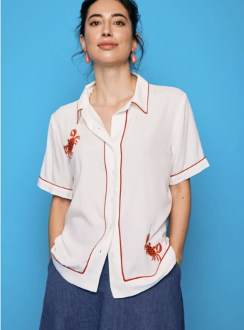 Camisa blanca estilo retro con ribetes rojos y cangrejo bordado en rojo. Diseño fresco y con personalidad. Encuéntrala en Dulce Locura, moda en Badajoz.