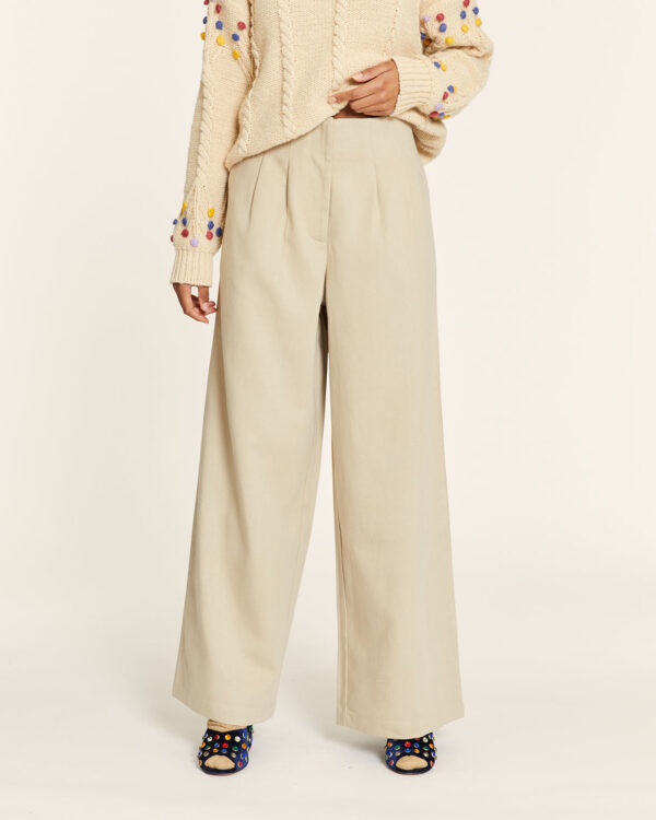 Pantalón Tencel beige con pinzas, cintura elástica trasera, bolsillos laterales y bajo por debajo del tobillo. Disponible en Dulce Locura, tienda de moda en Badajoz.