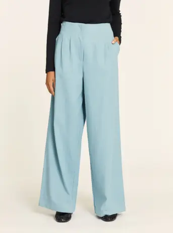 Pantalón Tencel denim azul claro con pinzas, cintura elástica trasera, bolsillos laterales y bajo por debajo del tobillo. Disponible en Dulce Locura, Badajoz.