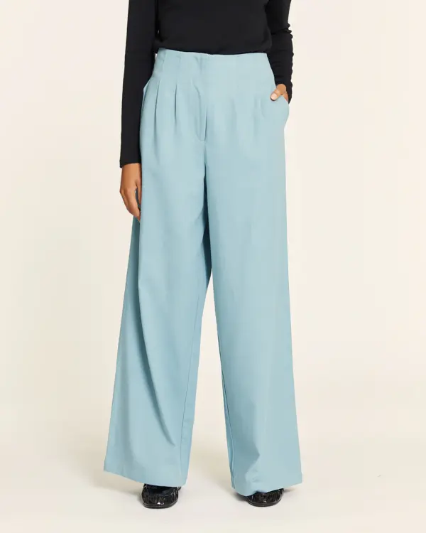 Pantalón Tencel denim azul claro con pinzas, cintura elástica trasera, bolsillos laterales y bajo por debajo del tobillo. Disponible en Dulce Locura, Badajoz.