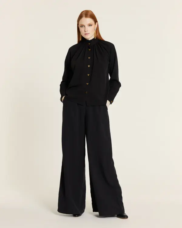 Pantalón fluido Tencel negro palazzo de pierna ancha y caída recta con cintura ajustada y bolsillos laterales. Disponible en Dulce Locura, tienda de moda en Badajoz.