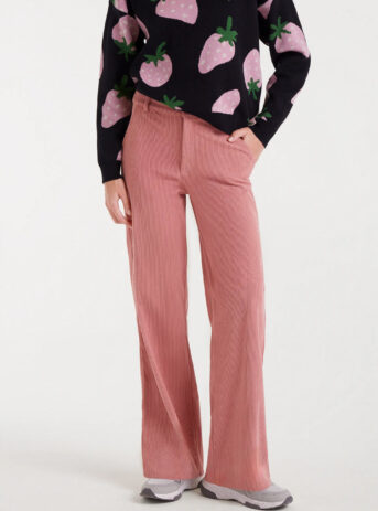 Pantalón de pana rosa con cintura fija de tiro medio, pernera recta, bolsillos laterales y cierre de cremallera con botón metálico. Disponible en Dulce Locura.