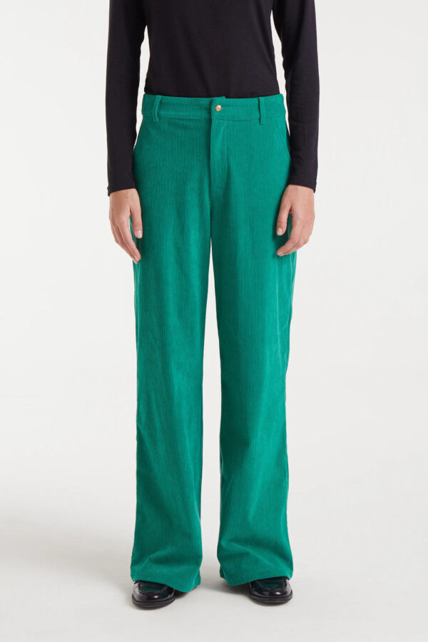 Pantalón de pana verde con tiro medio, pernera recta y cierre de cremallera y botón metálico. Disponible en Dulce Locura, tienda de moda en Badajoz.