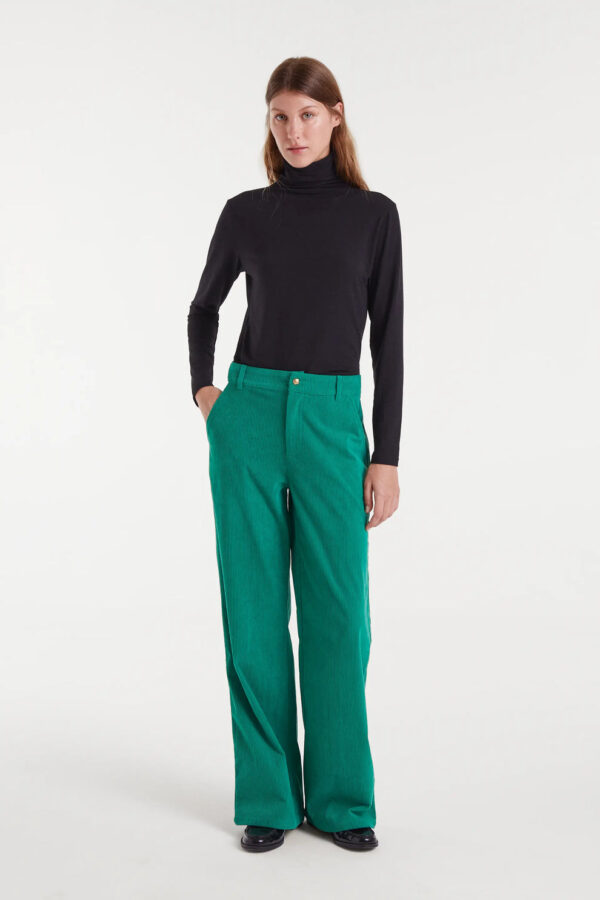 Pantalón de pana verde con tiro medio, pernera recta y cierre de cremallera y botón metálico. Disponible en Dulce Locura, tienda de moda en Badajoz.