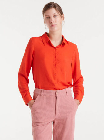Camisa fluida naranja de viscosa de bambú con cuello solapa y manga larga terminada en puño con botón. Disponible en Dulce Locura, tienda de moda en Badajoz.