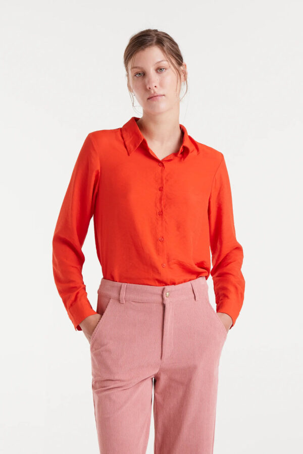 Camisa fluida naranja de viscosa de bambú con cuello solapa y manga larga terminada en puño con botón. Disponible en Dulce Locura, tienda de moda en Badajoz.