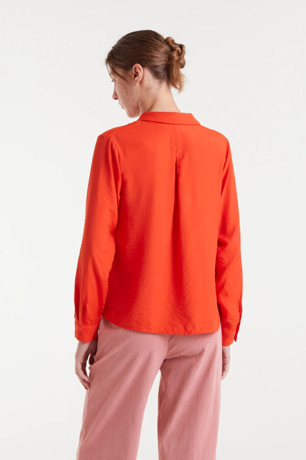 Camisa fluida naranja de viscosa de bambú con cuello solapa y manga larga terminada en puño con botón. Disponible en Dulce Locura, tienda de moda en Badajoz.