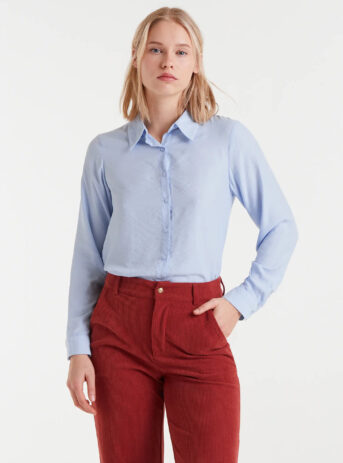 Camisa fluida azul de viscosa de bambú con cuello solapa, manga larga con puños y cierre frontal de botones. Disponible en Dulce Locura, tienda de moda en Badajoz.