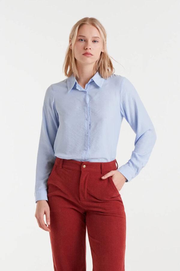 Camisa fluida azul de viscosa de bambú con cuello solapa, manga larga con puños y cierre frontal de botones. Disponible en Dulce Locura, tienda de moda en Badajoz.