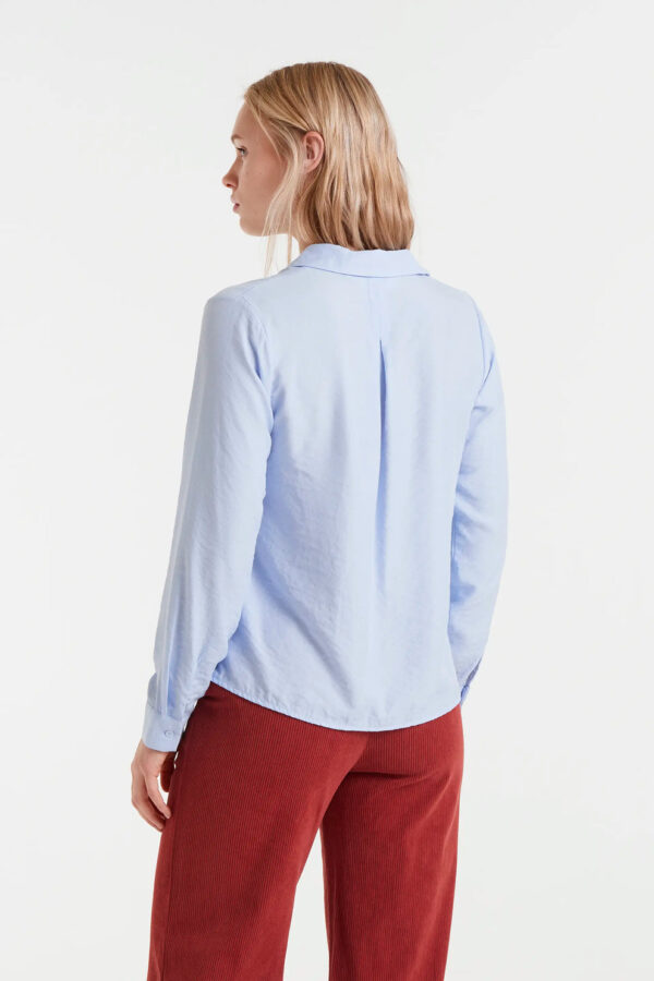 Camisa fluida azul de viscosa de bambú con cuello solapa, manga larga con puños y cierre frontal de botones. Disponible en Dulce Locura, tienda de moda en Badajoz.