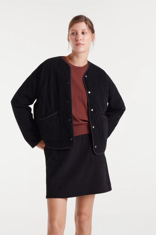 Chaqueta de pana negra con cuello pico, hombro caído, bolsillos laterales y cierre de botones a presión. Disponible en Dulce Locura, tienda de moda en Badajoz.