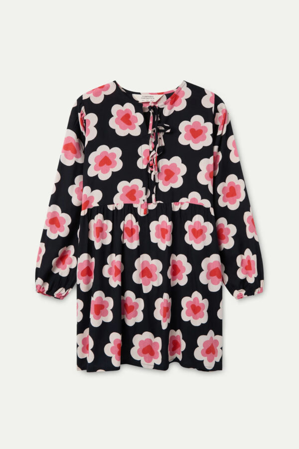 Vestido corto con estampado Sweetheart, cuello barco, escote anudado, manga larga con puño elástico y bolsillos laterales. Disponible en Dulce Locura.