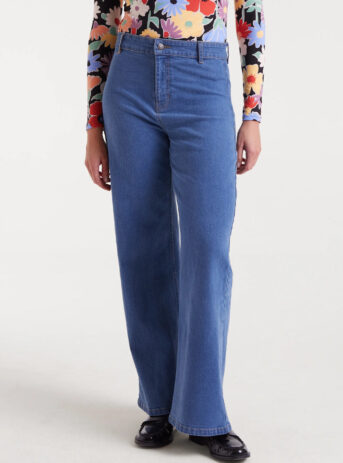 Pantalón vaquero azul de mujer en denim elástico con tiro alto, pernera recta y cierre de cremallera y botón. Disponible en Dulce Locura, tienda de moda en Badajoz.