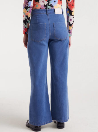 Pantalón vaquero azul de mujer en denim elástico con tiro alto, pernera recta y cierre de cremallera y botón. Disponible en Dulce Locura, tienda de moda en Badajoz.