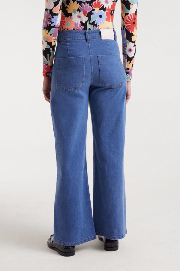 Pantalón vaquero azul de mujer en denim elástico con tiro alto, pernera recta y cierre de cremallera y botón. Disponible en Dulce Locura, tienda de moda en Badajoz.