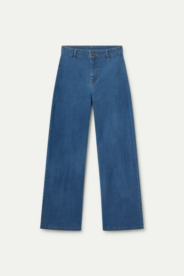 Pantalón vaquero azul de mujer en denim elástico con tiro alto, pernera recta y cierre de cremallera y botón. Disponible en Dulce Locura, tienda de moda en Badajoz.