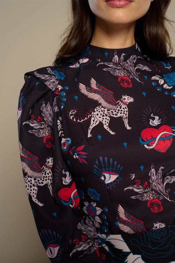 Mytho Top, blusa de manga larga con cuello Perkins y estampado de gatos alados y corazones. Cierre en espalda con botón. Disponible en Dulce Locura, Badajoz.