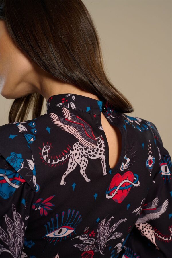 Mytho Top, blusa de manga larga con cuello Perkins y estampado de gatos alados y corazones. Cierre en espalda con botón. Disponible en Dulce Locura, Badajoz.