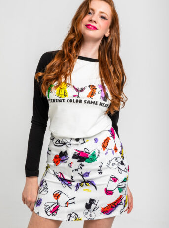 Mini falda Sixty blanca Imagine con ilustraciones de colores de niños de un centro de acogida. Colección benéfica. Disponible en Dulce Locura, Badajoz.