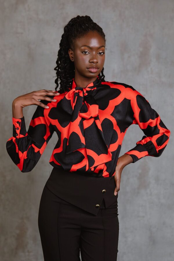 Red Bettina Top, blusa de manga larga con lazada al cuello, botones frontales y estampado mosaico rojo. Disponible en Dulce Locura, tienda de moda en Badajoz.