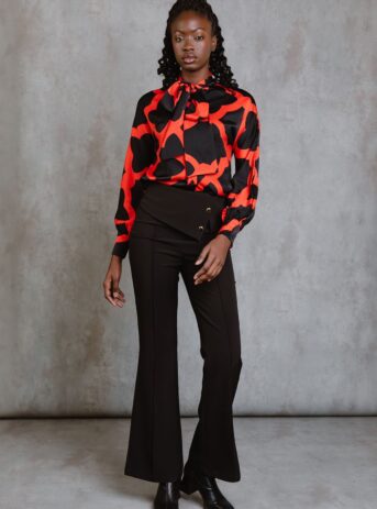 Red Bettina Top, blusa de manga larga con lazada al cuello, botones frontales y estampado mosaico rojo. Disponible en Dulce Locura, tienda de moda en Badajoz.