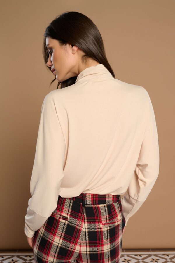 White Beata Top, blusa blanca en tejido elástico con cuello Perkins plisado y manga larga. Disponible en Dulce Locura, tienda de moda en Badajoz.
