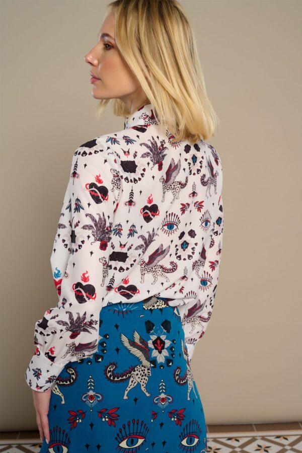 White Mytho Top, camisa blanca de manga larga con cuello solapa 70s y estampado de gatos alados. Disponible en Dulce Locura, tienda de moda en Badajoz.