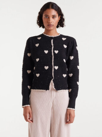 Cárdigan jacquard con estampado White Hearts. Con cuello redondo y manga larga abullonada. Cierre frontal con botones. Detalles en rib.
