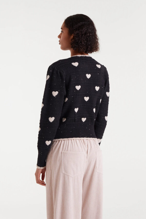 Cárdigan jacquard con estampado White Hearts. Con cuello redondo y manga larga abullonada. Cierre frontal con botones. Detalles en rib.