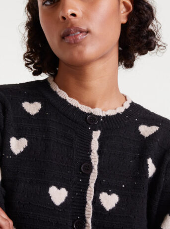 Cárdigan jacquard con estampado White Hearts. Con cuello redondo y manga larga abullonada. Cierre frontal con botones. Detalles en rib.