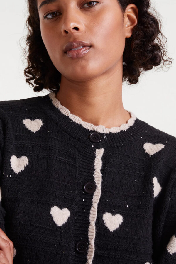 Cárdigan jacquard con estampado White Hearts. Con cuello redondo y manga larga abullonada. Cierre frontal con botones. Detalles en rib.